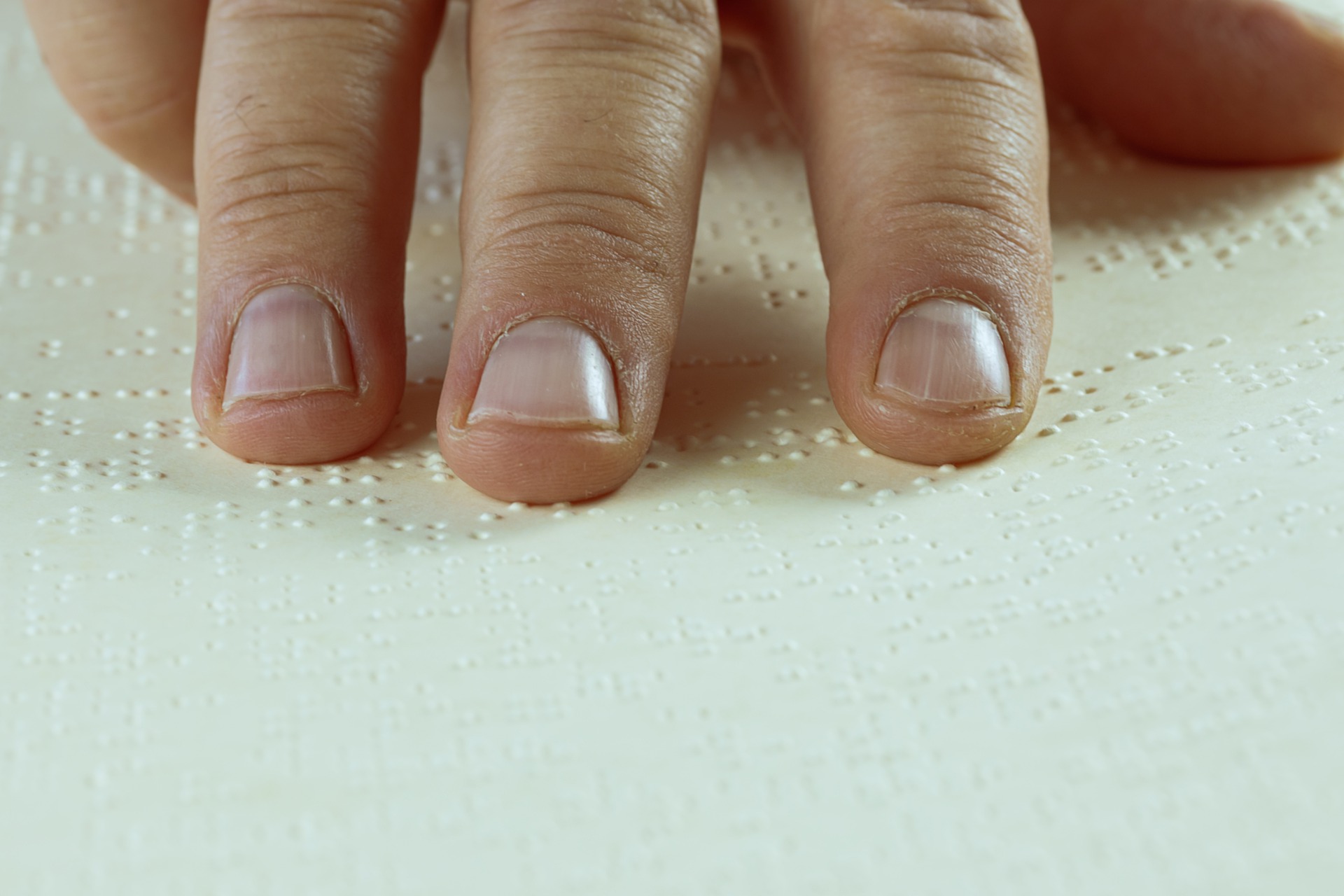 primer plano de la mano de una personas leyendo braile