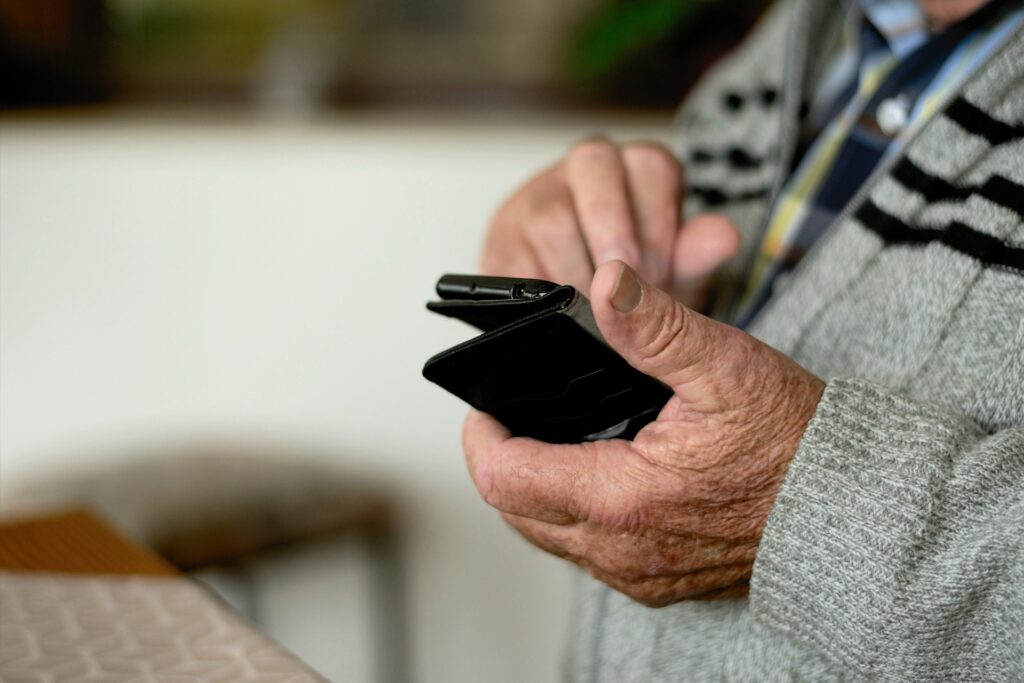 primer plano de un hombre mayor manejando un teléfono móvil; las tecnologías promueven la brecha digital con el colectivo de personas mayores. Hoy