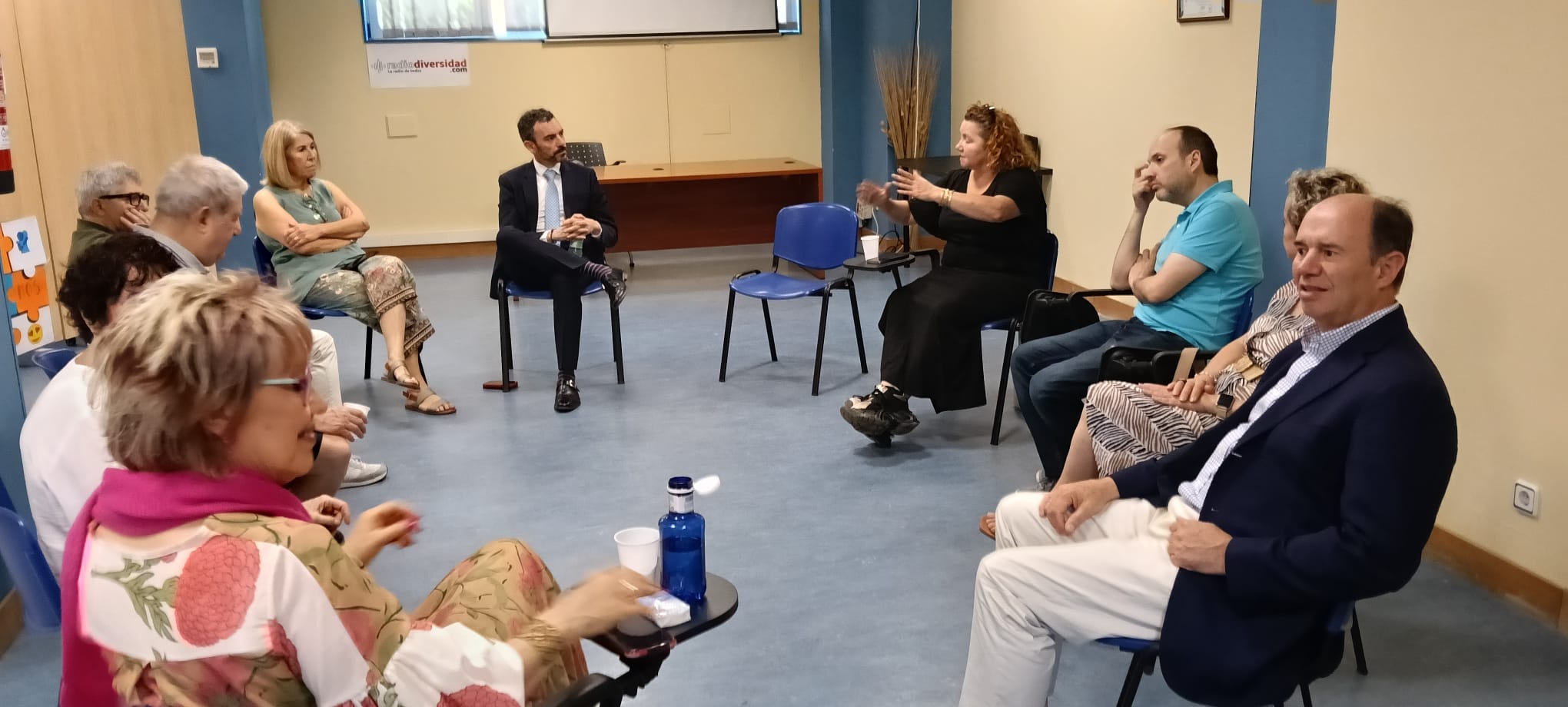 un grupo de personas sentadas en círculo, charlando