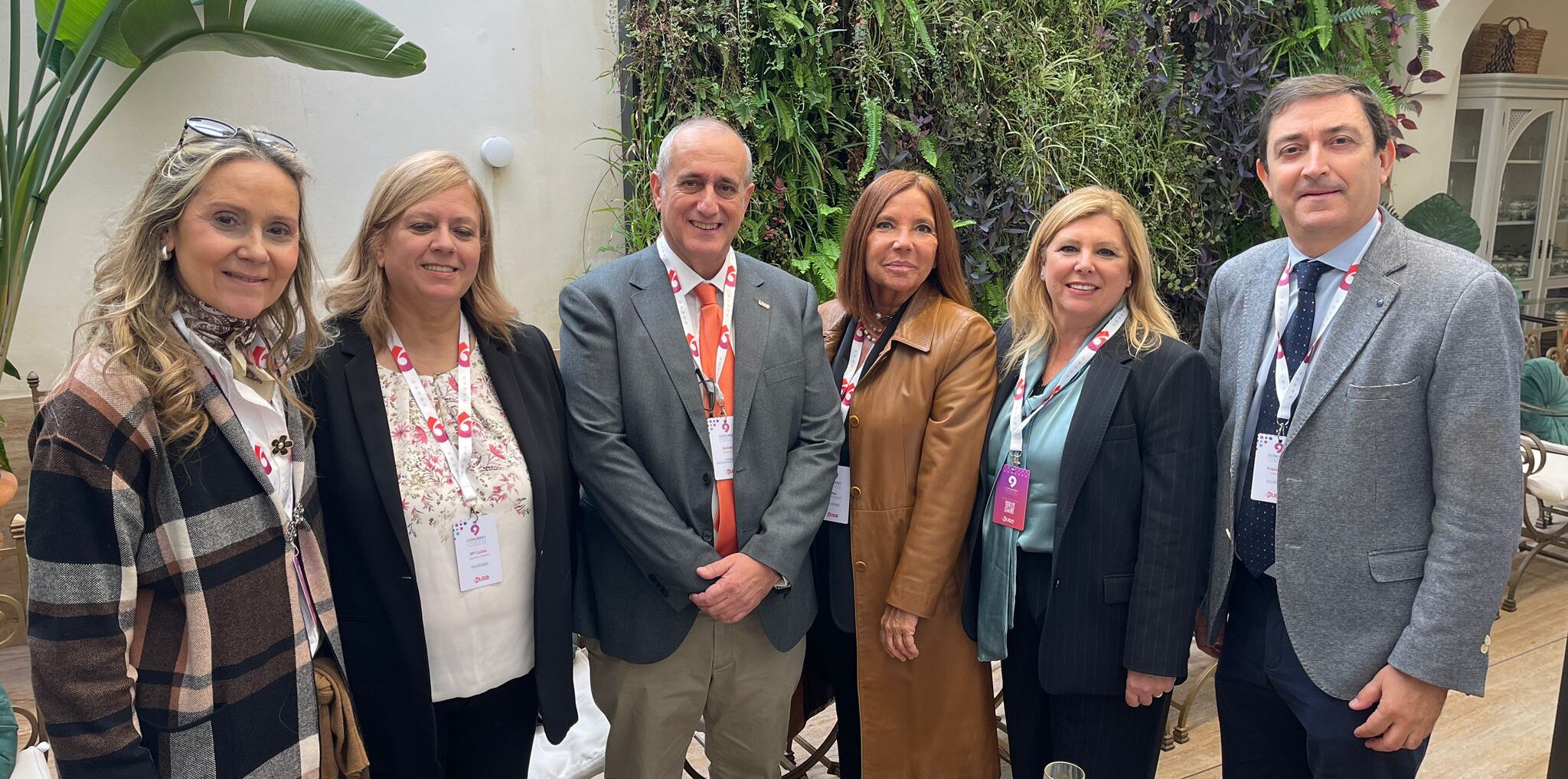 Cuatro mujeres y dos hombres posan de pie, mirando a cámara