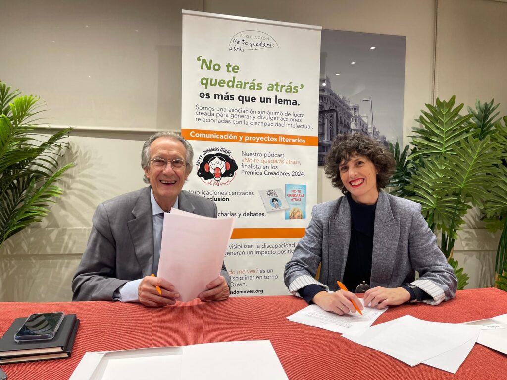 un hombre y una mujer sentados en una mesa ante unos papeles