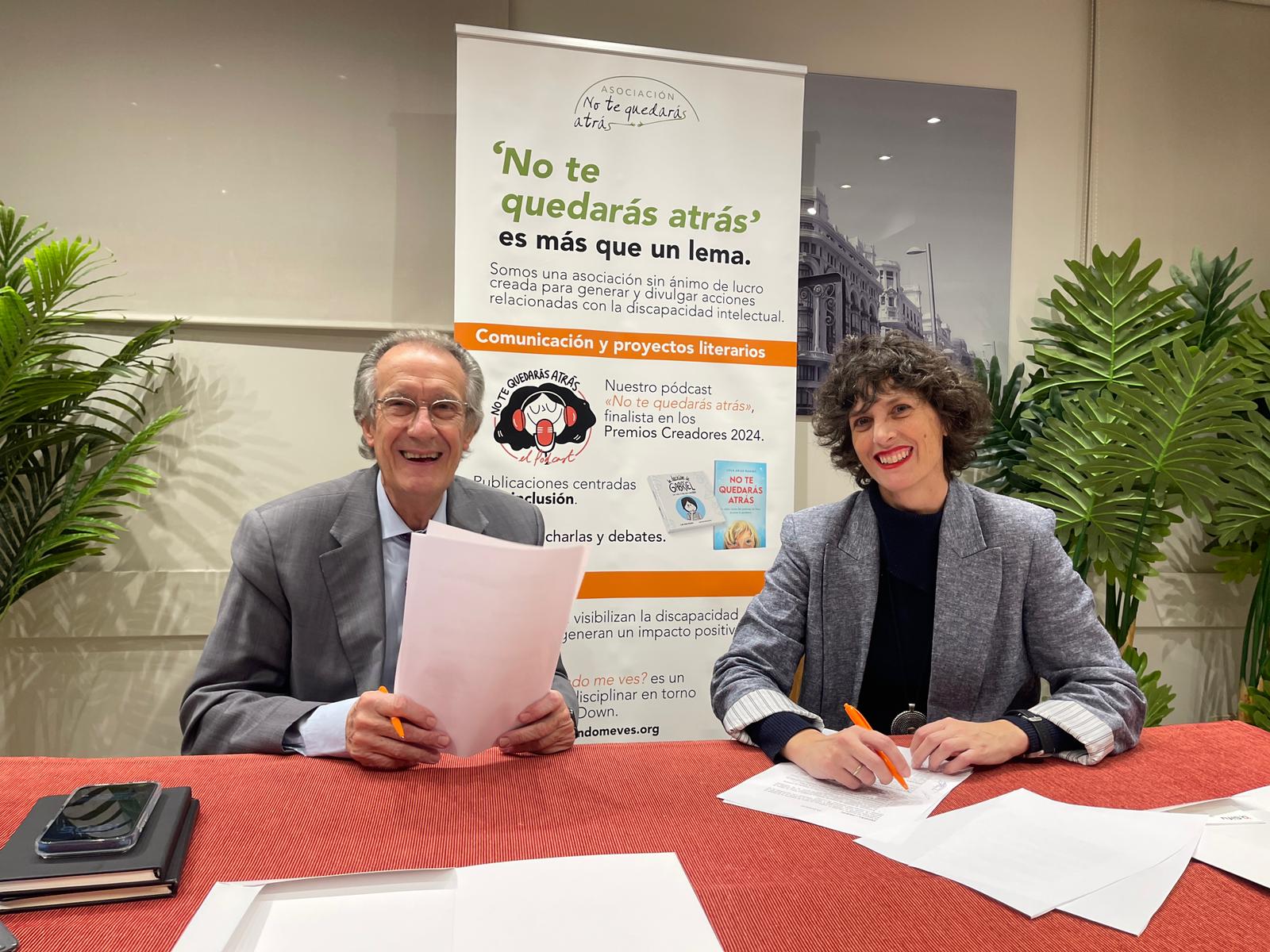 un hombre y una mujer sentados en una mesa ante unos papeles