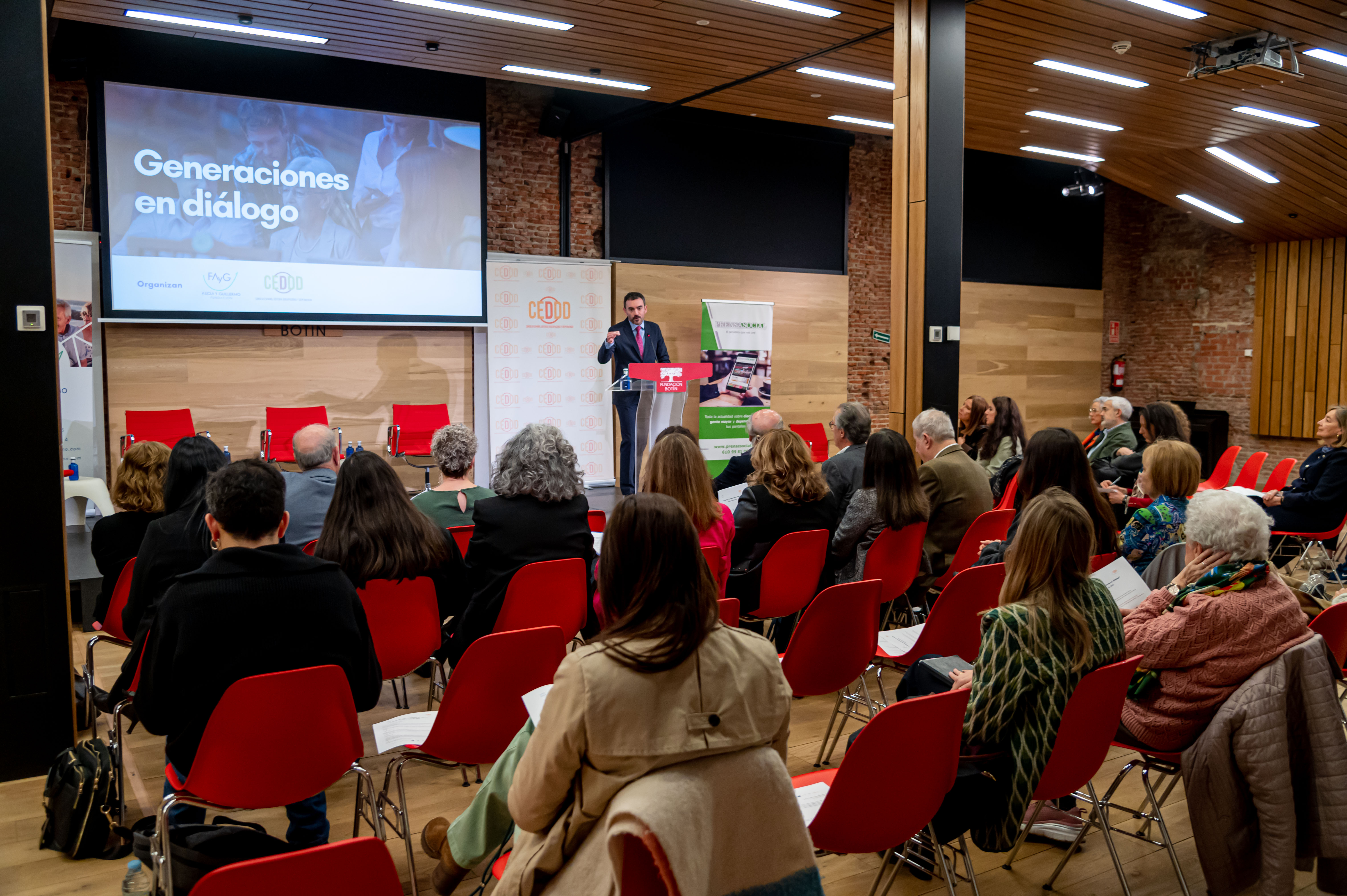 Un hombre tras un atril habla en una sala llena de gente