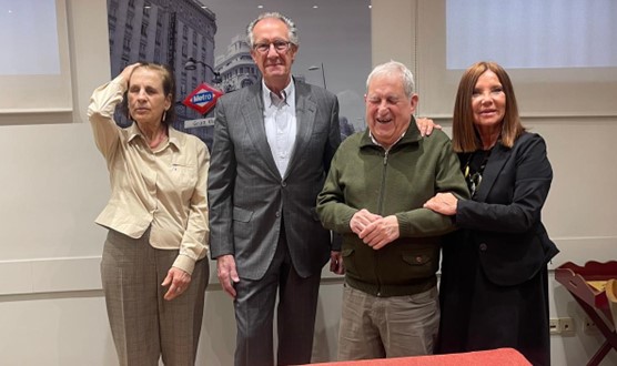 dos mujeres y dos hombres posan sonrientes de pie.