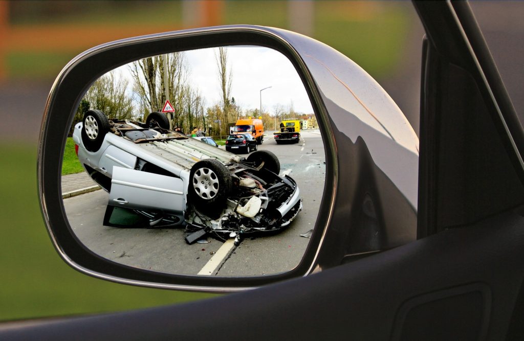coche volcado en accidente de tráfico, reflejado en un retrovisor.